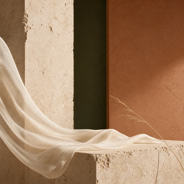 Ivory silk crossing sun-warmed limestone and terracotta in dry Mediterranean light.